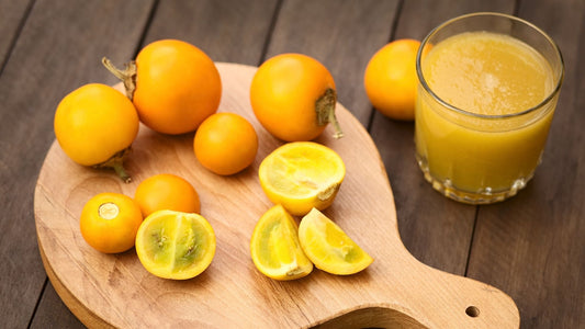Naranjilla or Lulo Fruits on a table and a glass with lulo juice